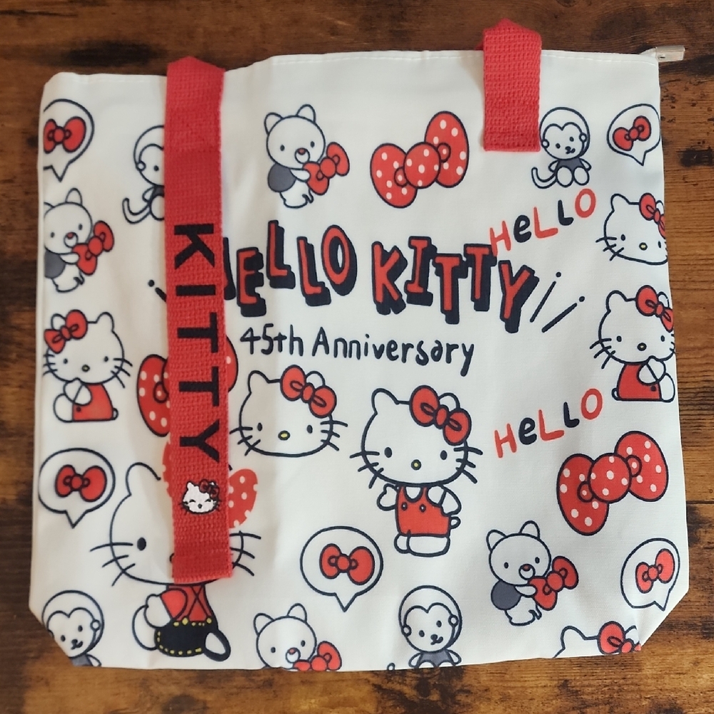 Charming Hello Kitty shoulder bag. Features cute Hello Kitty designs. Red straps